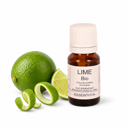 Flacone di olio essenziale di Lime Bio in vetro ambrato, con lime e foglie su fondo bianco — Citrus aurantifolia