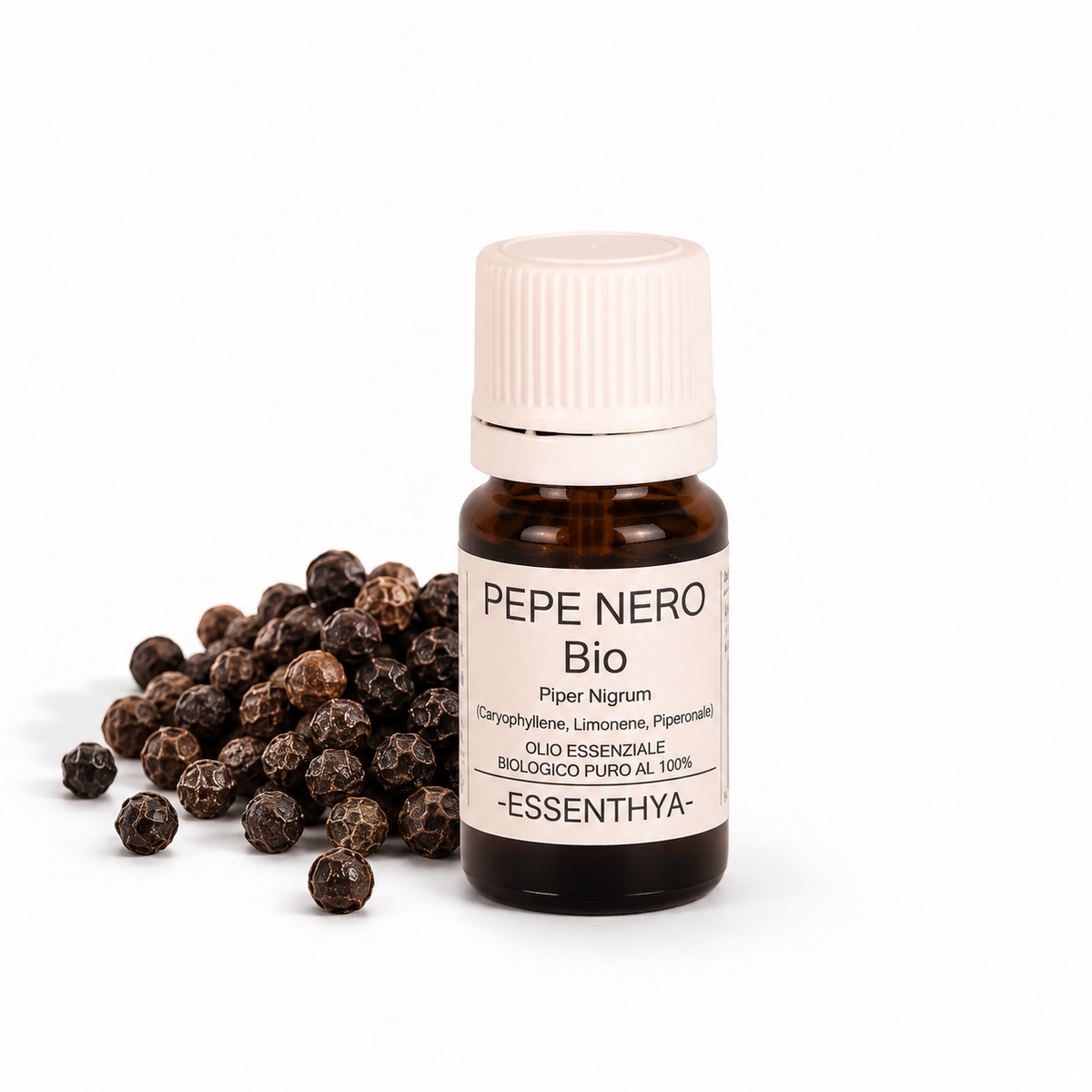 Flacone di olio essenziale di Pepe Nero Bio in vetro ambrato, con grani di pepe nero su fondo bianco — Piper nigrum